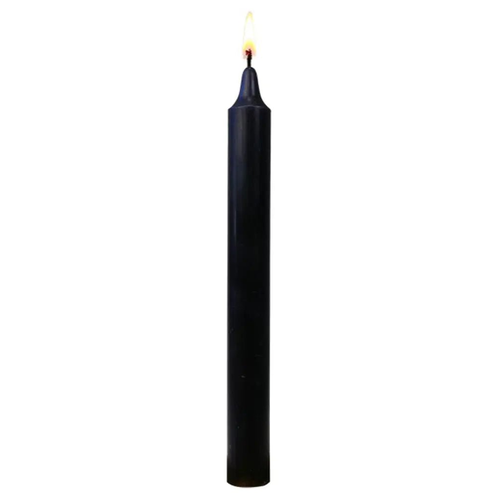 Bougie teintée dans la masse noire, longue et fine, allumée, isolée sur fond blanc.
