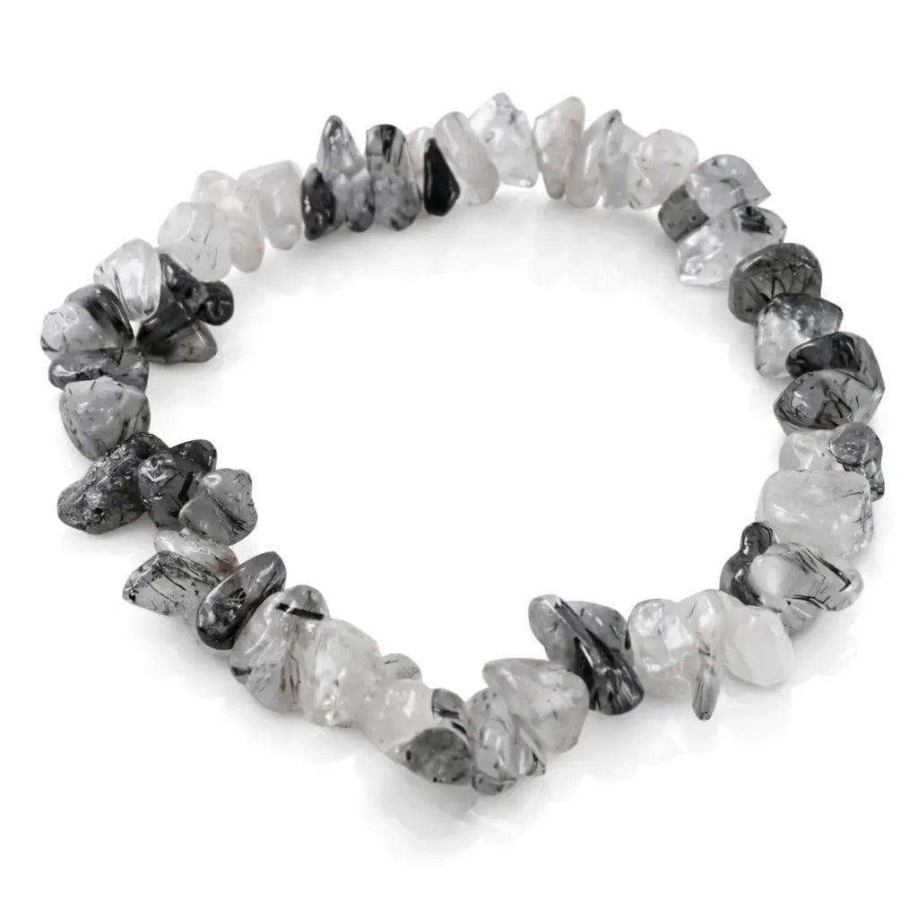 Un bracelet baroque en pierres naturelles de cristal de roche tourmaline, composé de petits éclats polis mêlant transparence et inclusions noires, montés sur un fil élastique, présenté sur un fond blanc.
