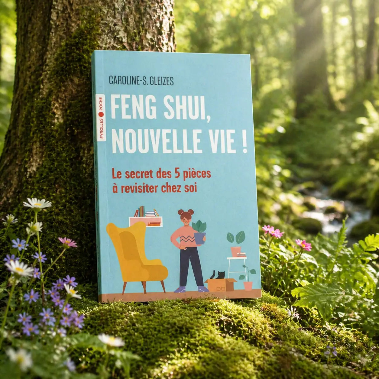 Livre bleu Feng Shui, nouvelle vie ! de Caroline Gleizes-Chevallier posé contre un arbre, illustré par une femme aménageant son salon avec des plantes et un fauteuil jaune.