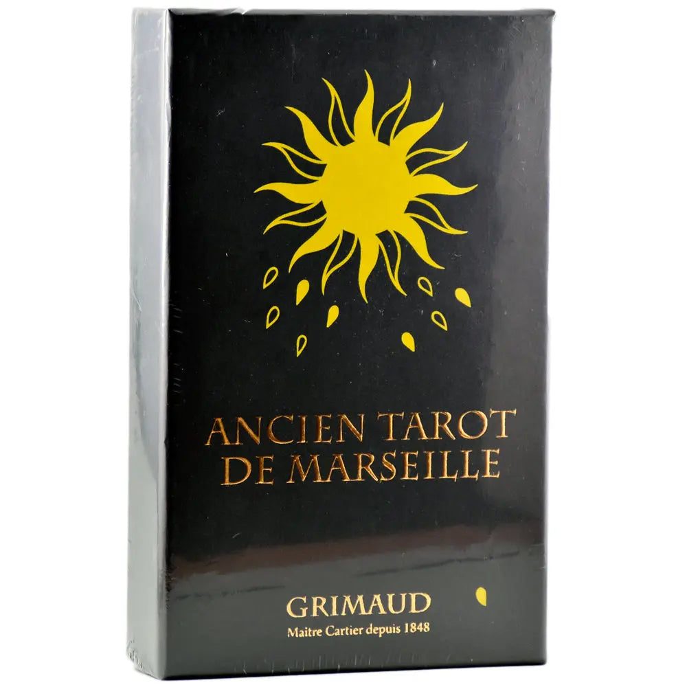 Coffret « Ancien Tarot de Marseille » (Grimaud) : boîte noire (filmée) avec un grand soleil jaune stylisé en haut et petits motifs jaunes dessous ; titre « ANCIEN TAROT DE MARSEILLE » en lettres dorées au centre ; mention « GRIMAUD – Maître Cartier depuis 1848 » en bas (L’Échoppe de Gaïa).