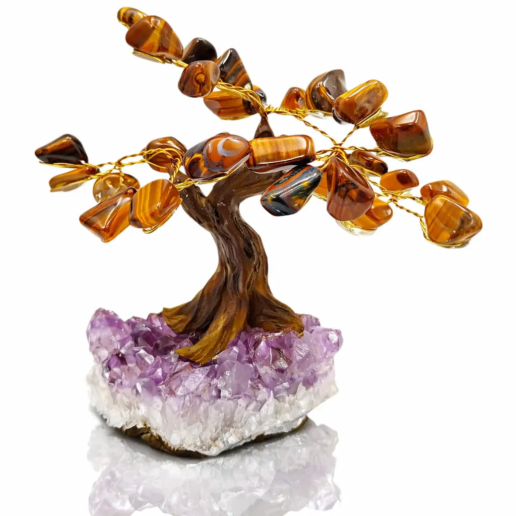 Un arbre du bonheur décoratif aux feuilles en pierres d'œil de tigre et branches dorées, s'élevant d'un socle en amas d'améthyste violette, présenté sur un fond blanc.