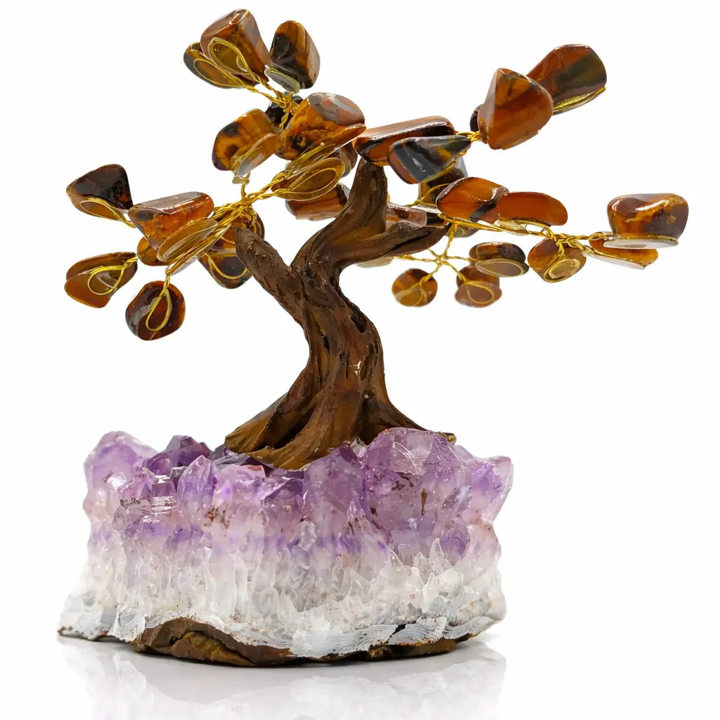 Un arbre du bonheur décoratif avec un tronc sculpté et des feuilles en œil de tigre, s'élevant d'un socle en amas d'améthyste violette, présenté sur un fond blanc.