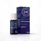 Un flacon de 10 ml d'huile essentielle de bois de siam de la marque Herbes & Traditions, accompagné de son étui en carton bleu foncé assorti, présenté sur un fond blanc.