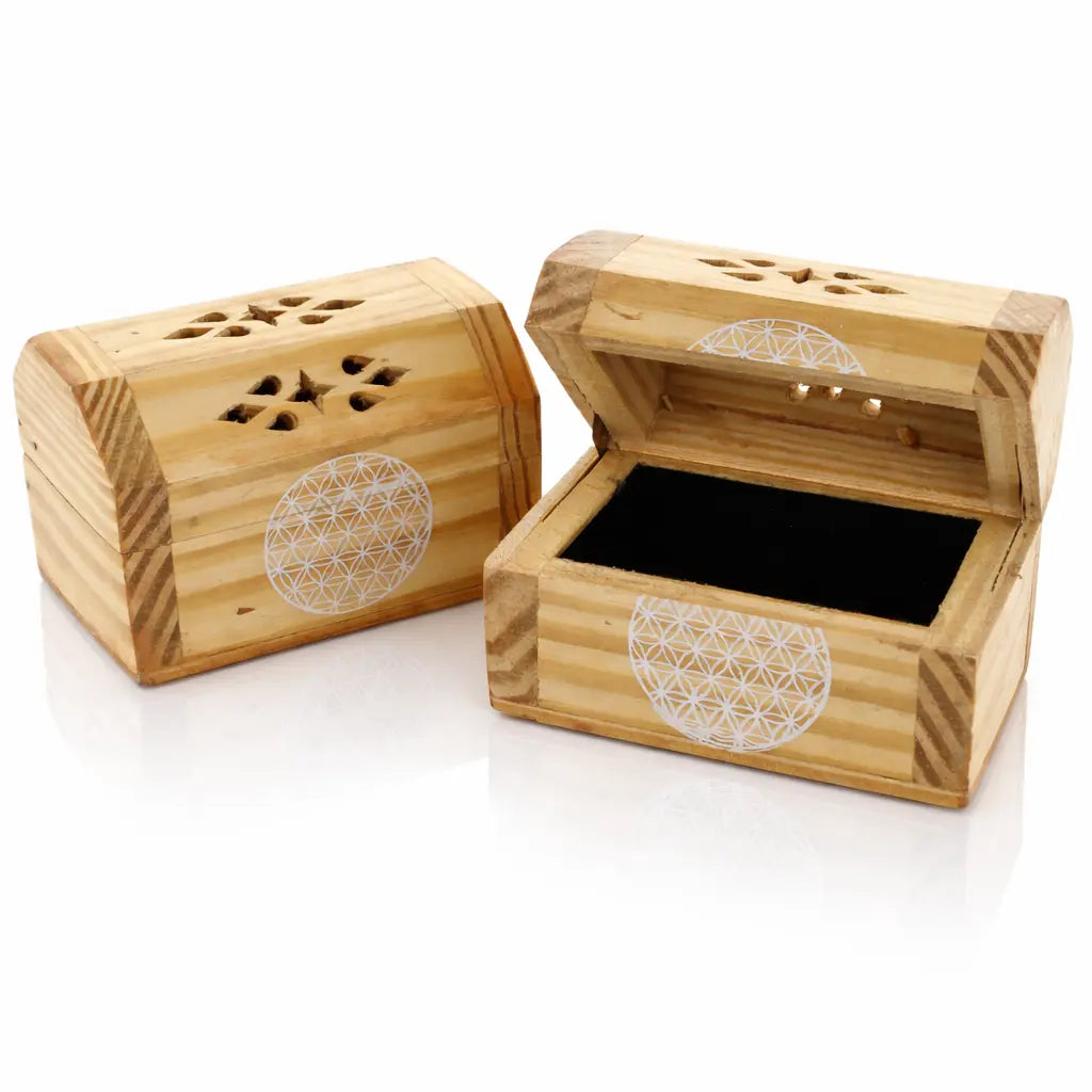 Deux petites boîtes en bois de style coffre, décorées d'un motif Fleur de Vie blanc et de découpes ciselées sur le couvercle, l'une fermée et l'autre ouverte révélant un intérieur noir, présentées sur un fond blanc.