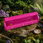 Boîte Porte Encens en Bois Manguier - Soleil & Lune Pink peinte en rose vif et entrouverte sur une souche moussue, montrant ses coupelles intérieures dorées pour encens.