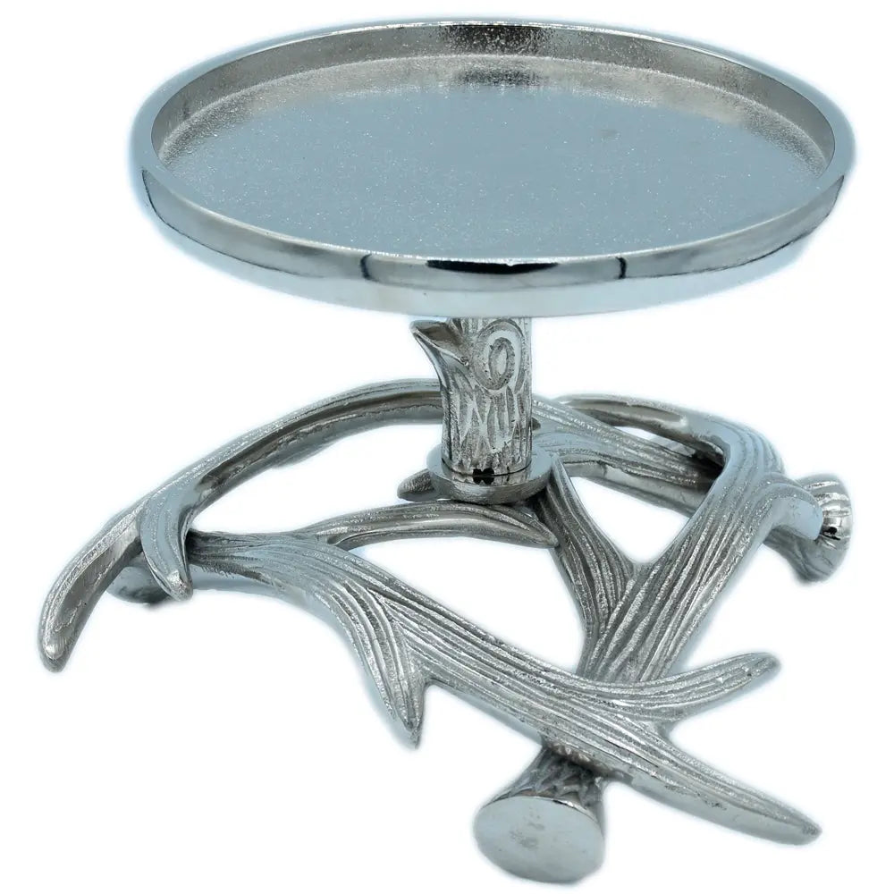 Un bougeoir en métal argenté composé d'une coupelle circulaire montée sur un socle original imitant des bois de cerf entrelacés, présenté sur un fond blanc.