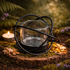 Bougeoir photophore verre et métal noir mat avec structure circulaire entourant un verre transparent.