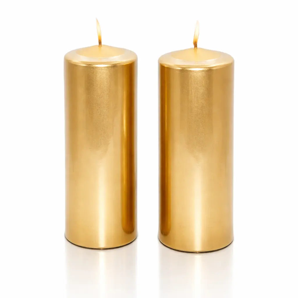 Un lot de deux bougies piliers métallisées dorées, de forme cylindrique, présentées debout sur un fond blanc avec un léger reflet à leur base.
