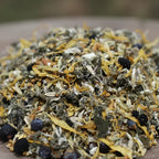 Gros plan sur un mélange d’encens en vrac composé d’herbes séchées, de fleurs jaunes et de petites baies sombres.