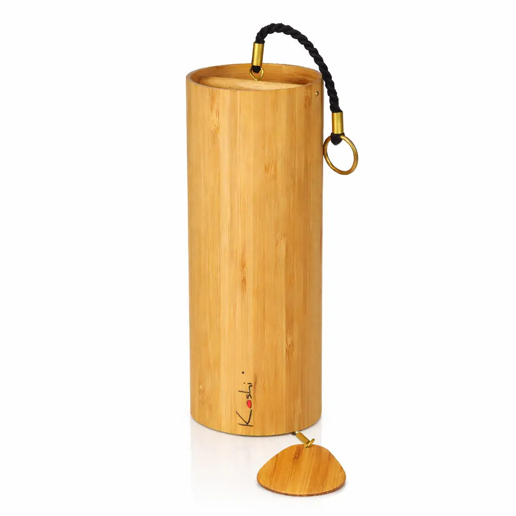 Un carillon Koshi Ignis, composé d'un tube de résonance en bambou naturel orné du logo Koshi avec un point rouge, avec une attache en corde noire et un battant en bois, présenté sur un fond blanc.