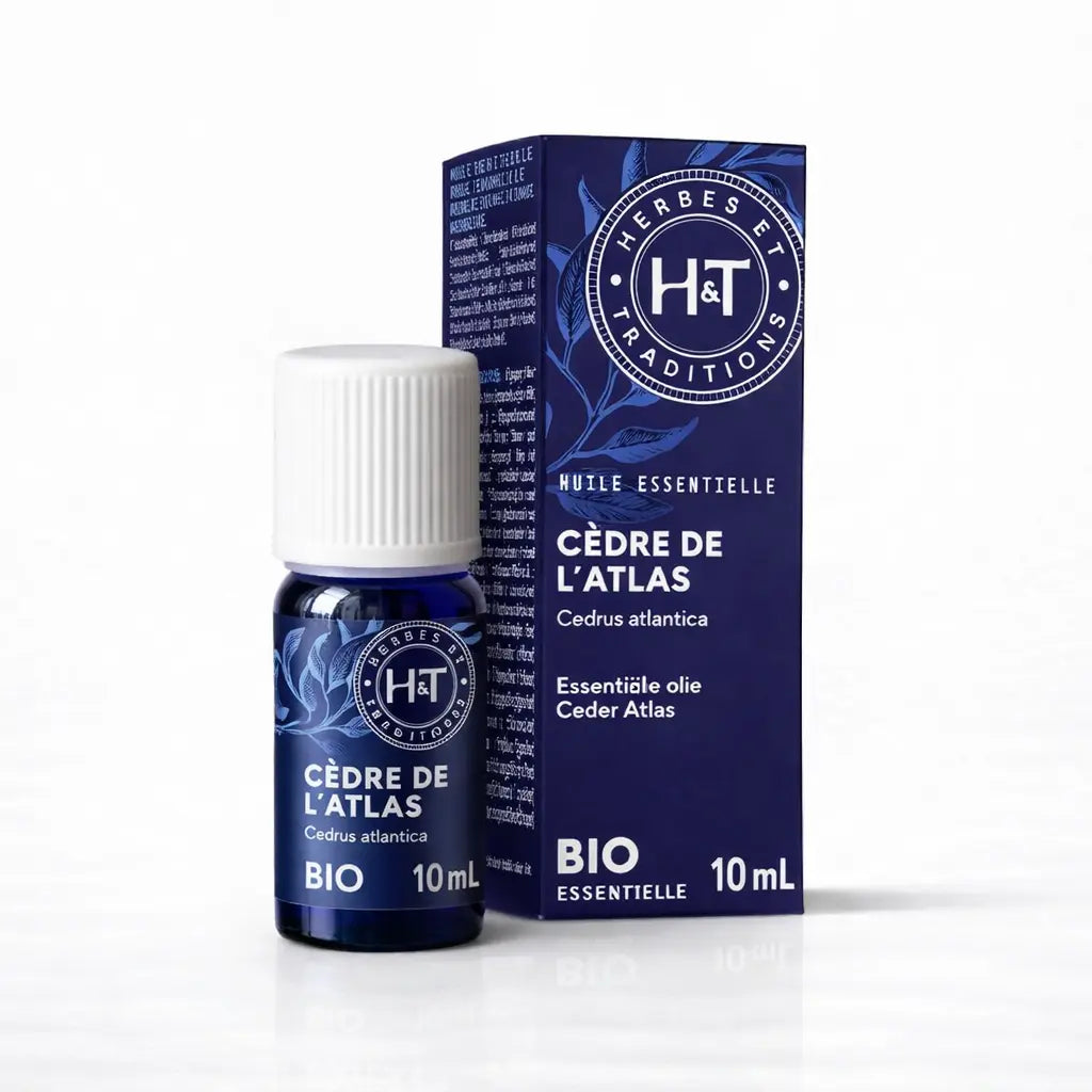 Un flacon de 10 ml et son emballage d'huile essentielle de Cèdre de l'Atlas (Bio) de la marque Herbes & Traditions, présentés sur un fond blanc épuré.