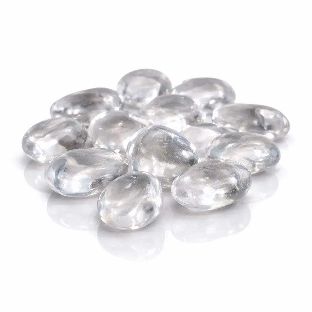 Un groupe de pierres de cristal de roche roulées d'une grande transparence et aux surfaces lisses, présenté sur un fond blanc avec des reflets brillants.