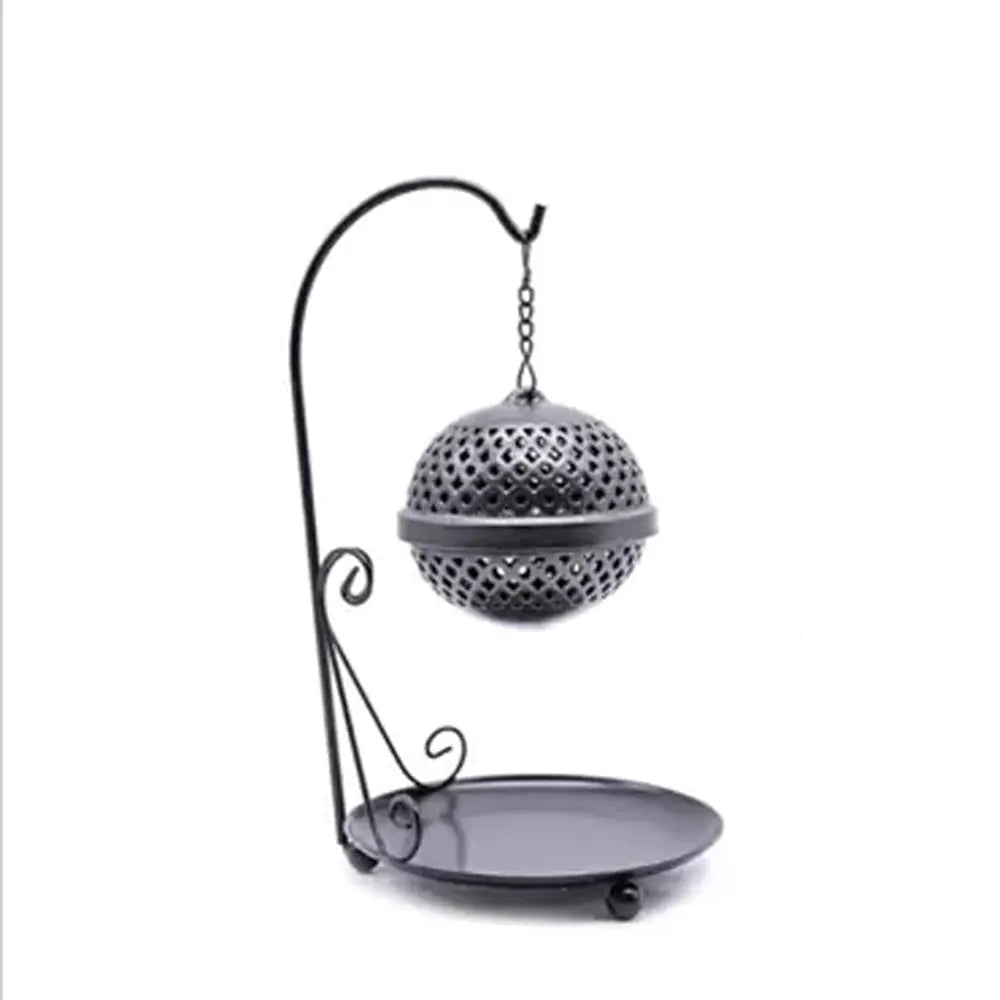Encensoir sphère suspendue en métal noir, boule ajourée sur chaîne et potence, plateau rond de récupération, sur fond blanc.