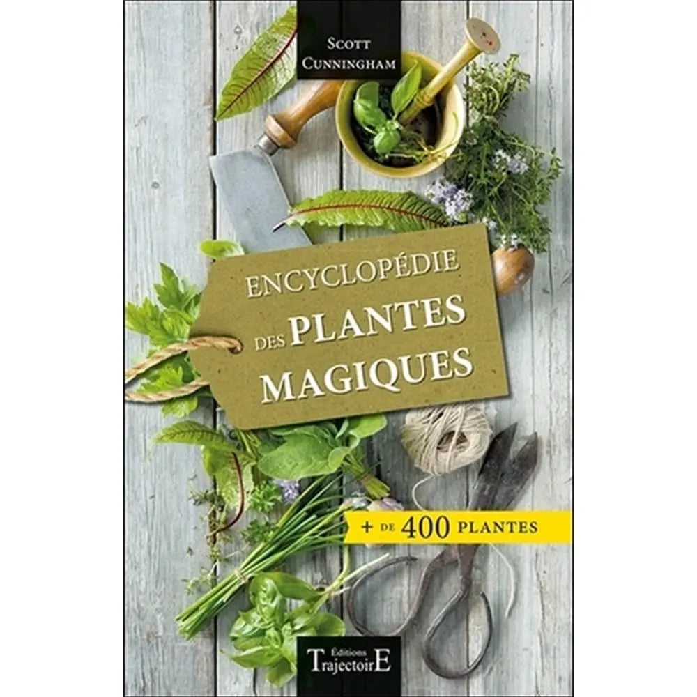 Livre Encyclopédie des plantes magiques de Scott Cunningham avec herbes fraîches et outils de jardinage.