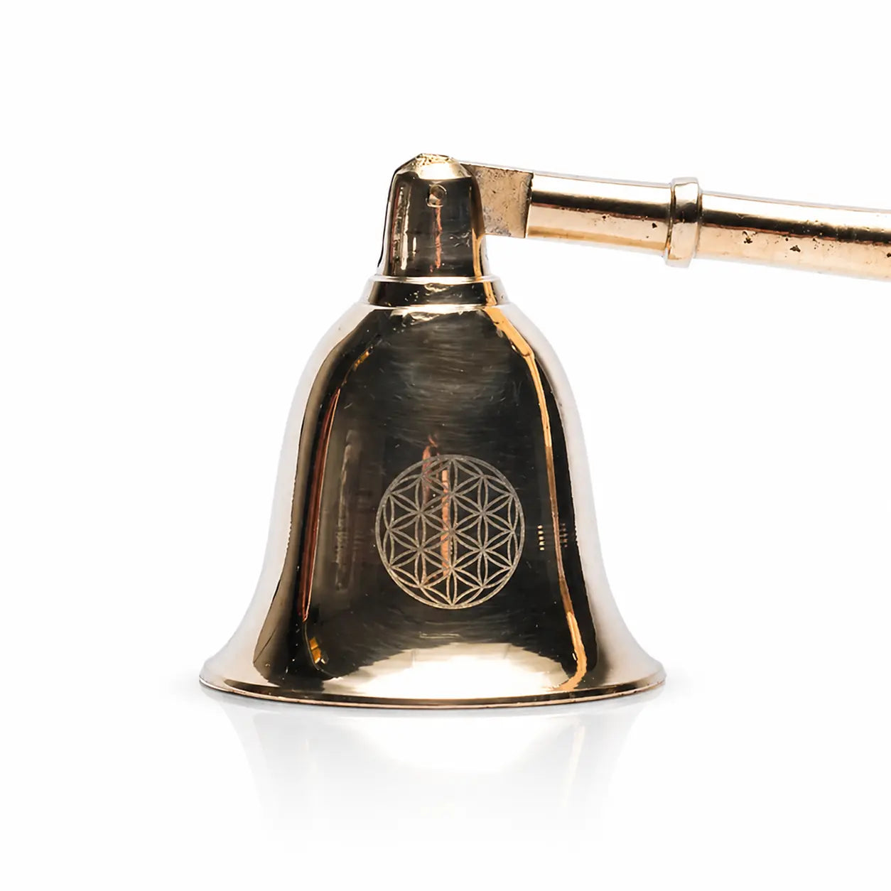 Gros plan sur la cloche d'un éteignoir à bougie dorée avec gravure du symbole Fleur de Vie.
