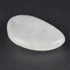 Un galet cristal de roche poli de forme ovale, blanc laiteux, présenté seul sur un fond noir.