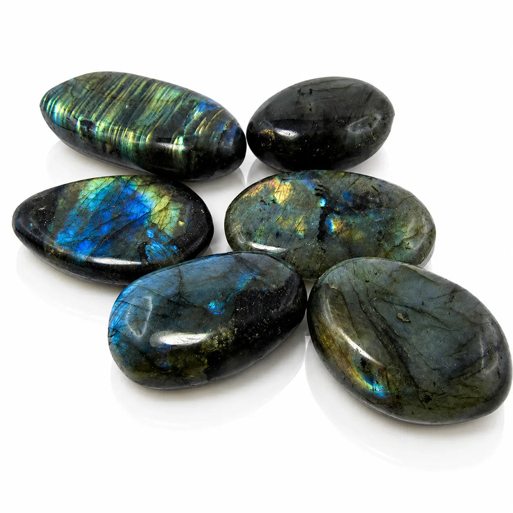 Labradorite - Galet, illustré par un groupe de galets lisses et polis révélant des iridescences caractéristiques aux nuances bleu électrique, dorées et vertes.