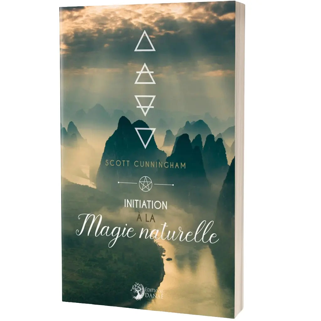 Couverture du livre Initiation à la Magie naturelle de Scott Cunningham aux Éditions Danaé. L'illustration présente un paysage montagneux brumeux survolé par les symboles géométriques des quatre éléments.