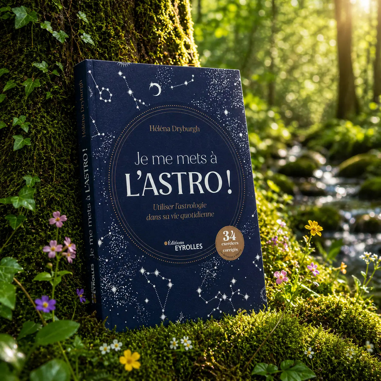 Livre bleu nuit Je me mets à l'Astro ! d'Hélèna Dryburgh posé dans la mousse forestière, illustré de constellations et d'un croissant de lune.