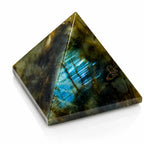 Labradorite - Pyramide, illustré par une pierre taillée et polie en forme de pyramide à base carrée, dont l'une des faces révèle un éclat irisé bleu turquoise intense et strié.