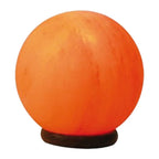 Lampe de sel rose de l'Himalaya taillée en sphère allumée sur un socle en bois rond