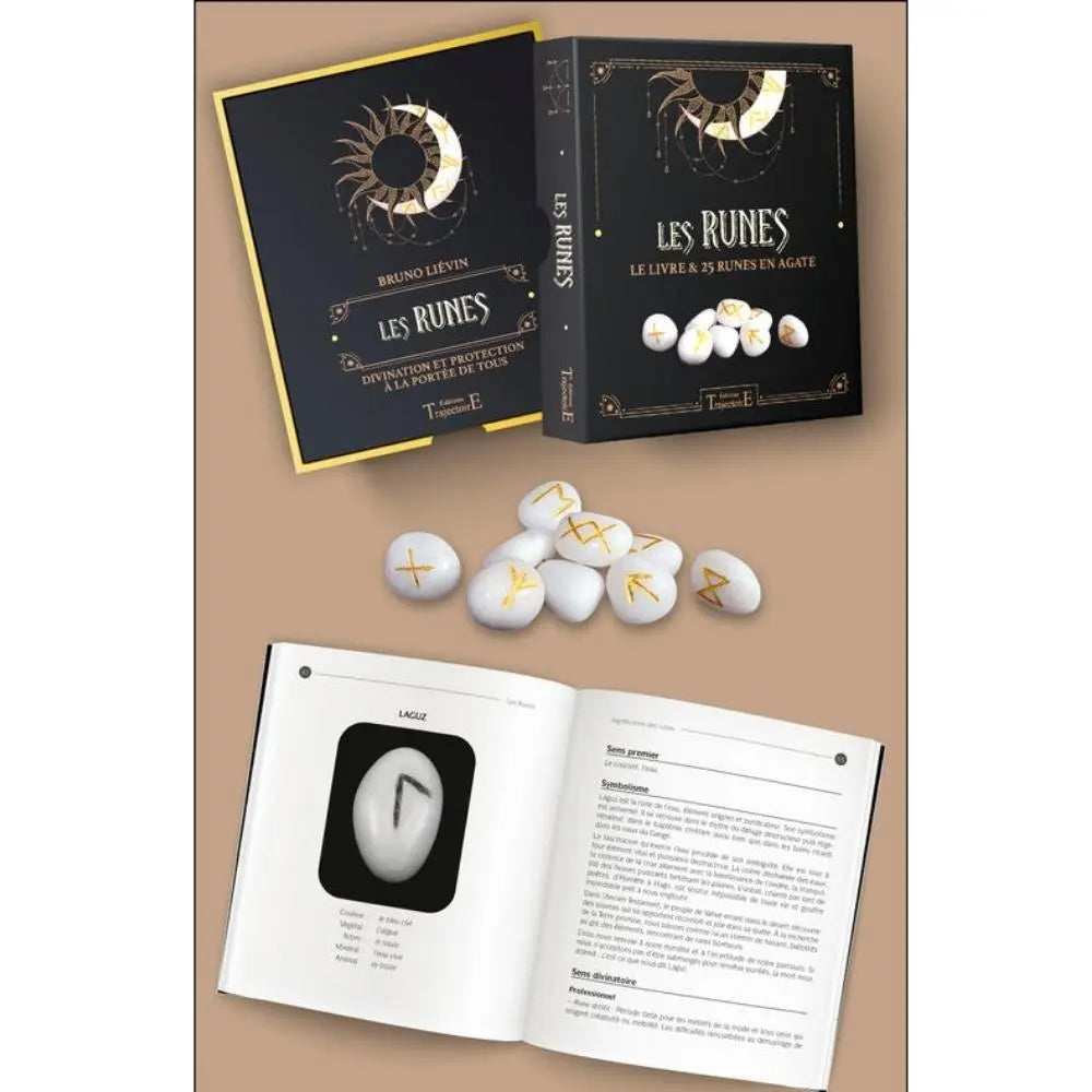 Coffret Les Runes avec livre et runes en agate, boîte noire et or, pierres blanches gravées et pages intérieures du guide ouvertes.