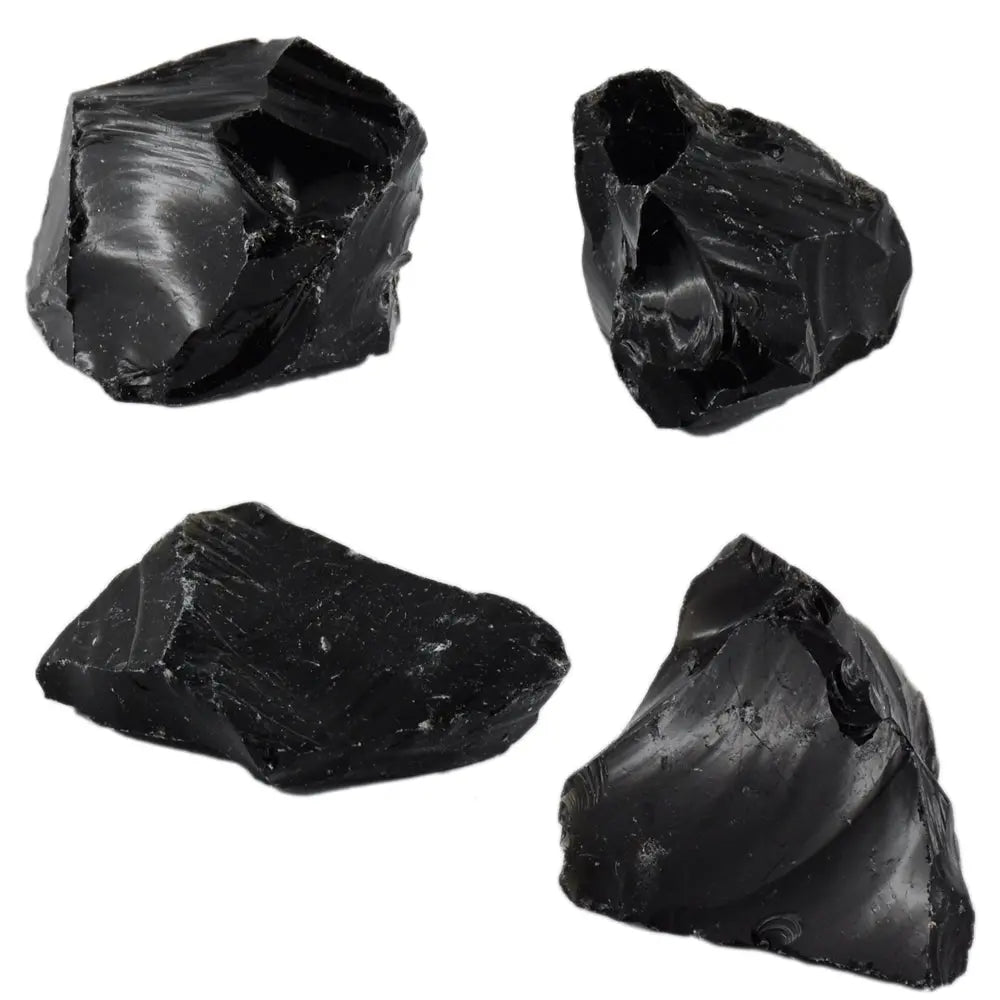 Plusieurs morceaux d'obsidienne noire brute aux surfaces vitrées et tranchantes, présentant des reflets sombres naturels, regroupés sur un fond blanc uni.
