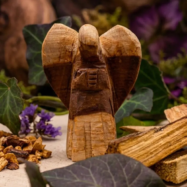 Ange en bois sculpté entouré de bâtons de palo santo brut, bois beige doré sur support naturel.