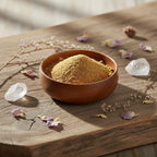Palo santo en poudre pour fumigation, fine poudre dorée dans une coupelle en bois sur planche rustique avec cristaux et pétales.