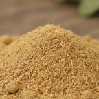 Palo santo en poudre pour fumigation, fine poudre doré-brun en tas en gros plan sur fond de bois.