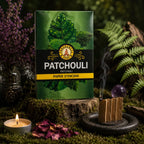 Carnet vert de Papier d'Encens Fragrances & Sens - Patchouli illustré de feuilles de patchouli, posé près d'une lamelle allumée en accordéon exhalant de la fumée.