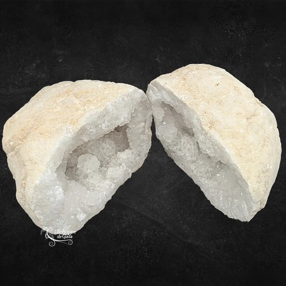 Deux moitiés d'une géode de quartz blanc montrant la croûte rocheuse beige et le cœur cristallin.