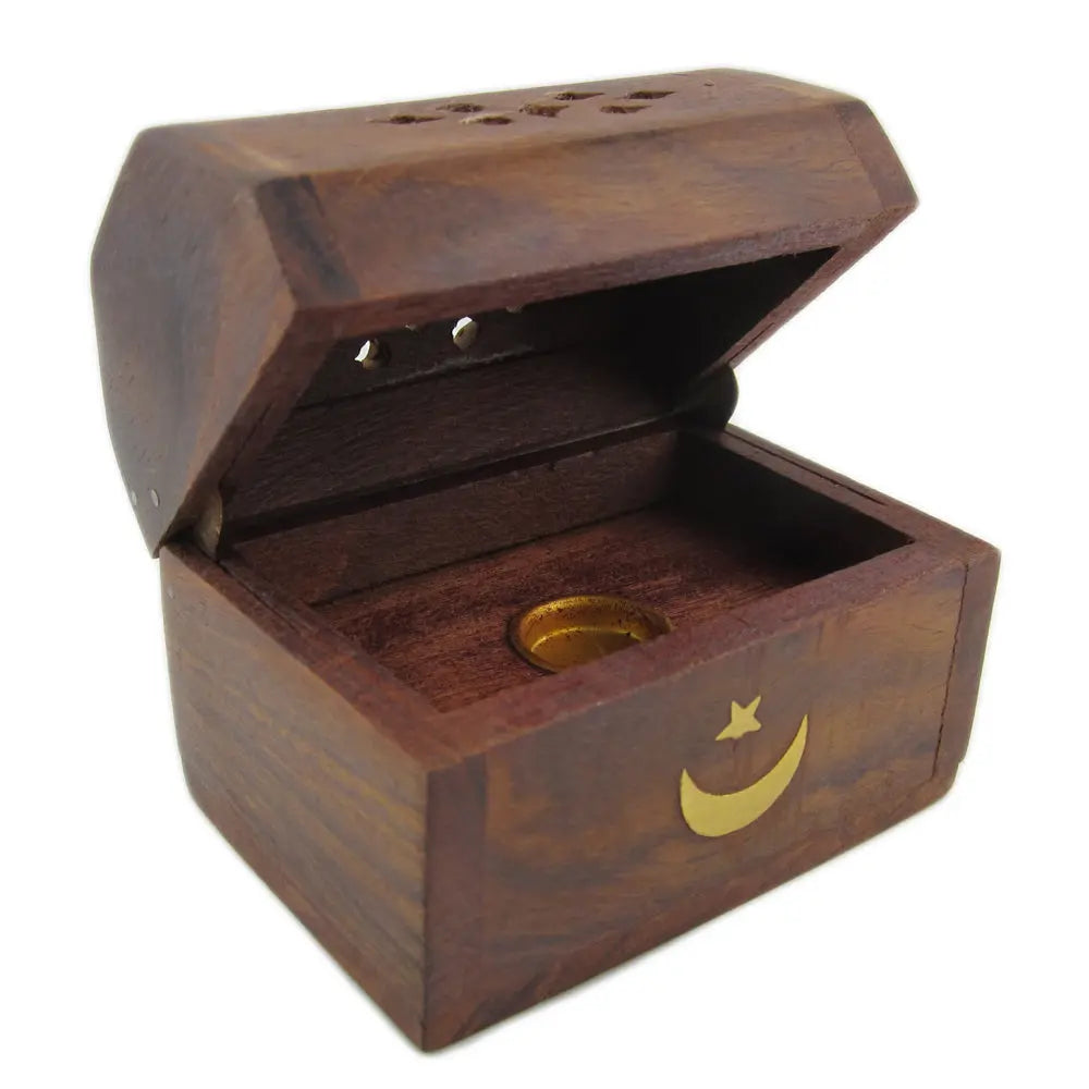 Un porte-encens en forme de petit coffret en bois foncé, orné d'un croissant de lune et d'une étoile dorés, avec un couvercle ajouré pour diffuser la fumée, présenté ouvert sur un fond blanc.