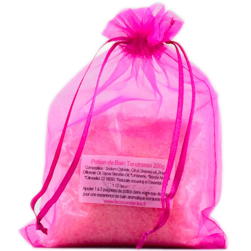 Sachet en organza rose vif rempli de sels de la Potion de bain Tendresse sur fond blanc