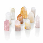 Plusieurs cristaux polis en forme de pointes de quartz hématoïde aux teintes blanches, roses et orangées sont disposés sur un fond blanc neutre.