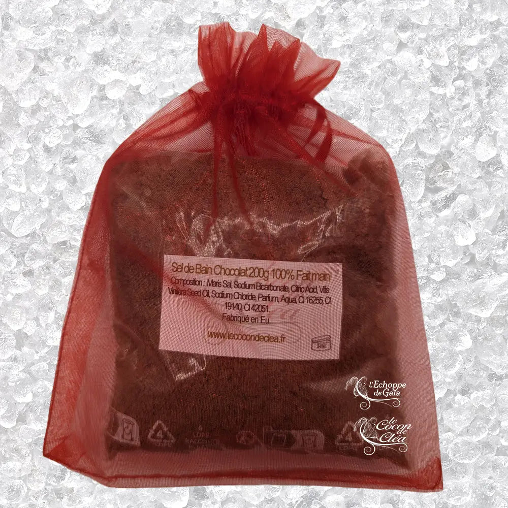 Sachet en organza rouge rempli de Sel de bain chocolat artisanal 200g sur un fond de cristaux blancs.