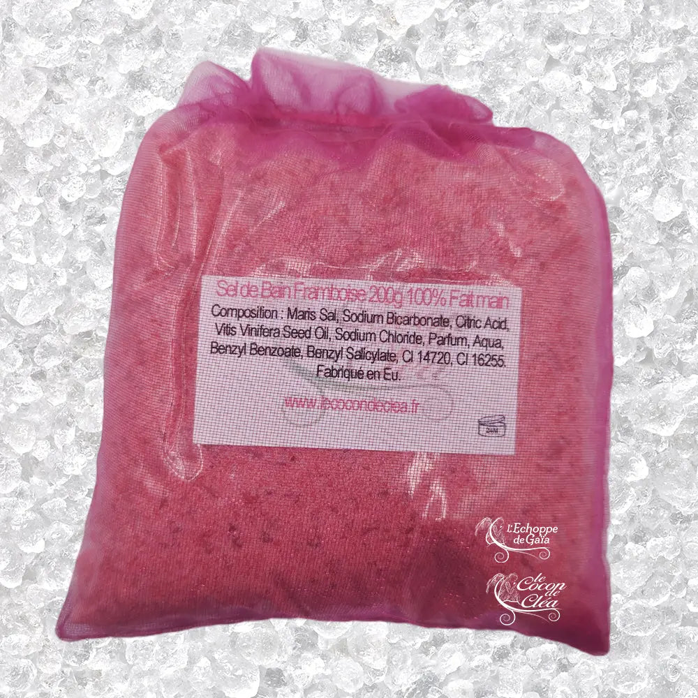Sachet en organza rose rempli de Sel de bain framboise artisanal 200g sur un fond de cristaux blancs.