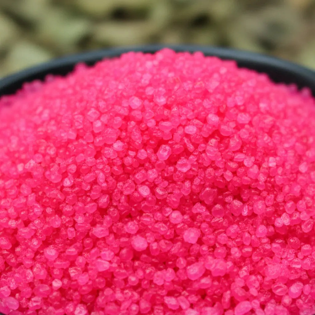 Gros plan sur des cristaux de sel infusé Accueil Chaleureux, texture cristalline rose vif.