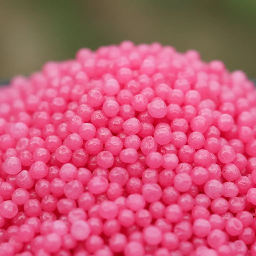 Gros plan sur les grains ronds rose vif du sel infusé Cerise