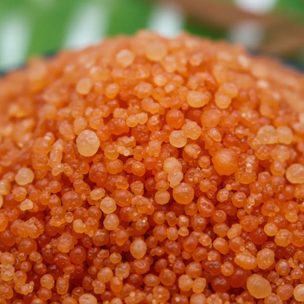 Gros plan sur des cristaux de sel infusé Coeur de Foyer, texture cristalline orange.
