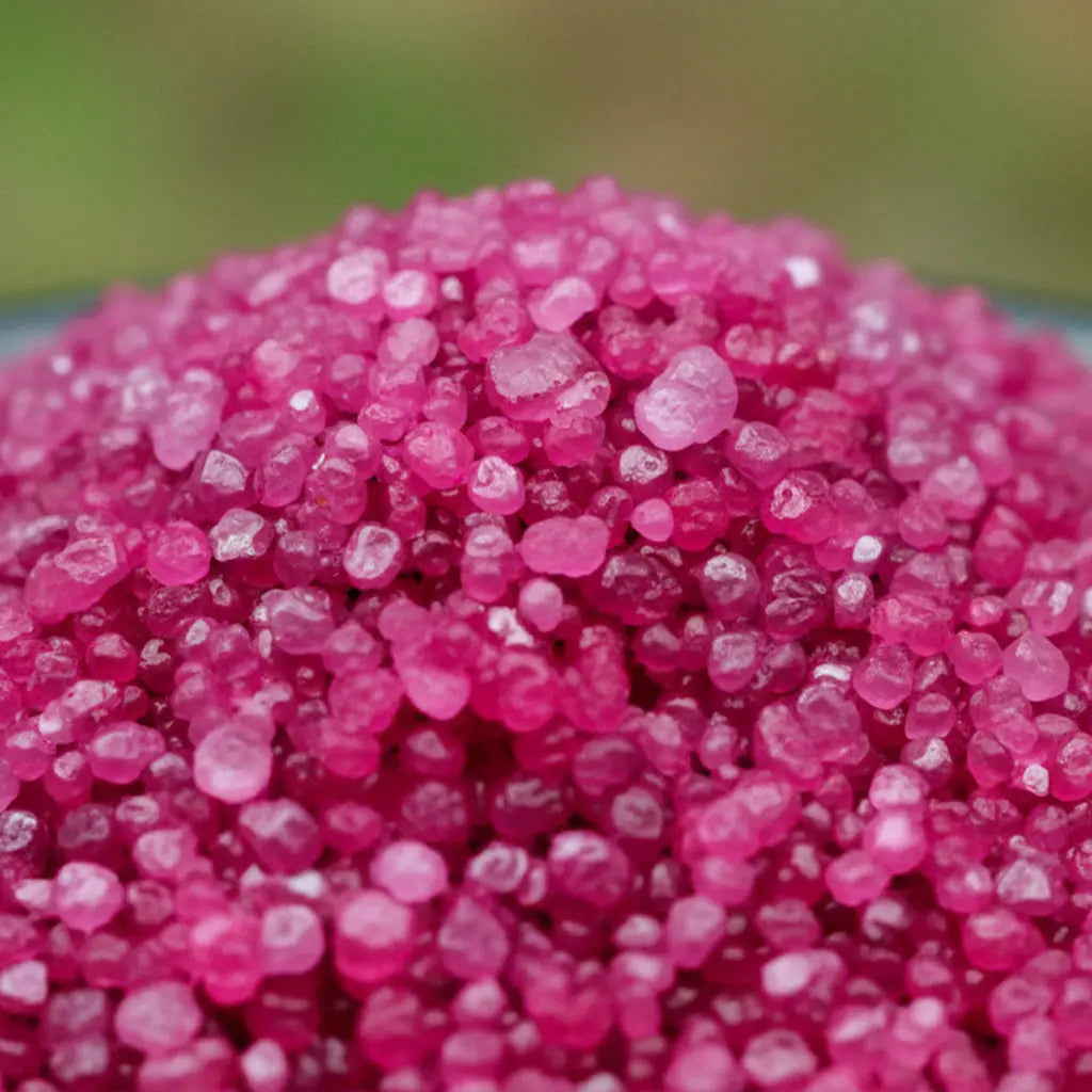 Gros plan sur des cristaux de sel infusé Zone de Confort, texture cristalline rose fuchsia.